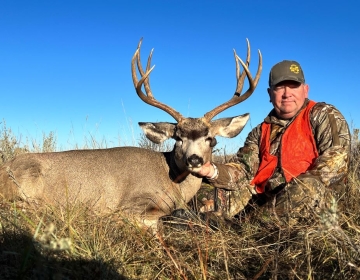 A mule deer hunter with his trophy in Northeastern Wyoming